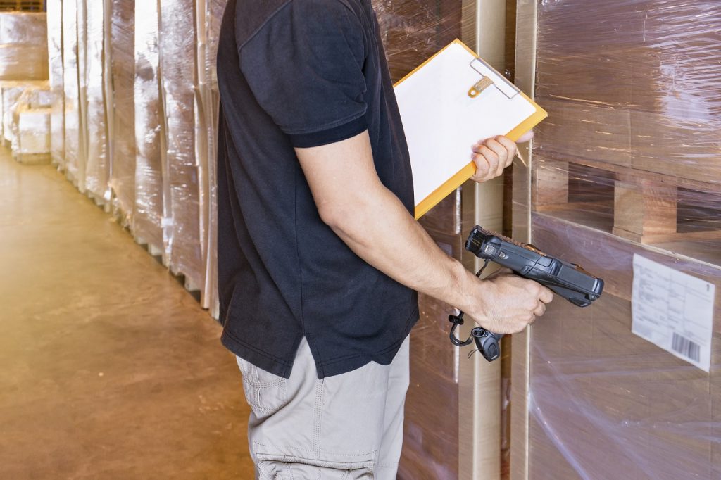 A man scanning the RFID of boxes in a warehouse