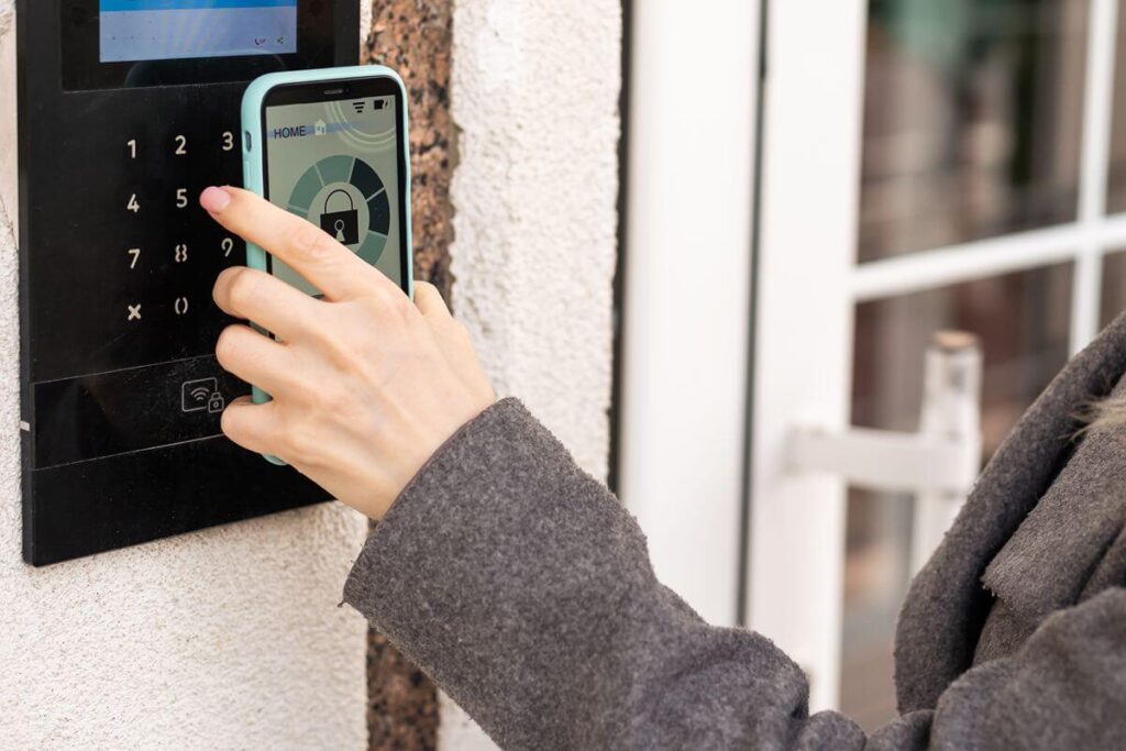 Person using a smartphone credential at an electronic door access keypad