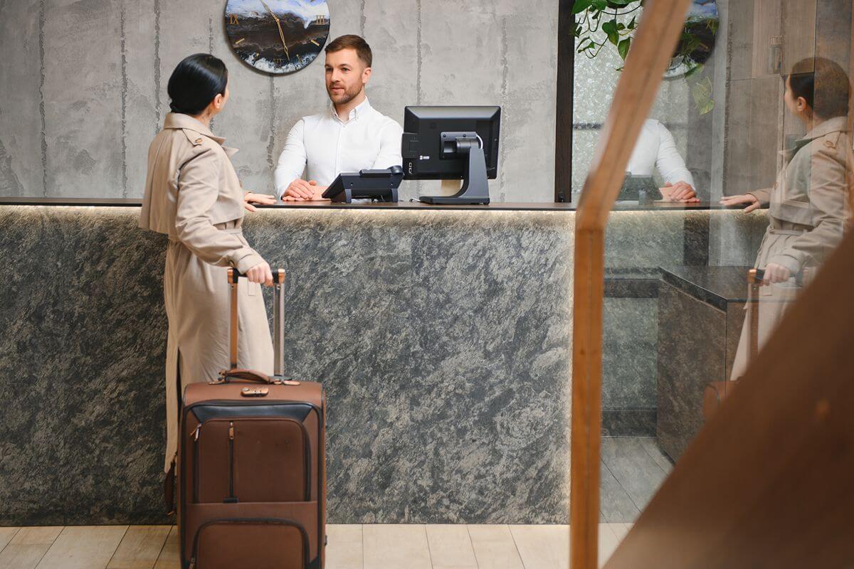 Hotel guest speaking with front desk staff at a hotel reception counter