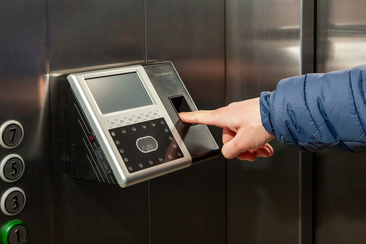 Employee using a fingerprint scanner for secure biometric access inside a workplace